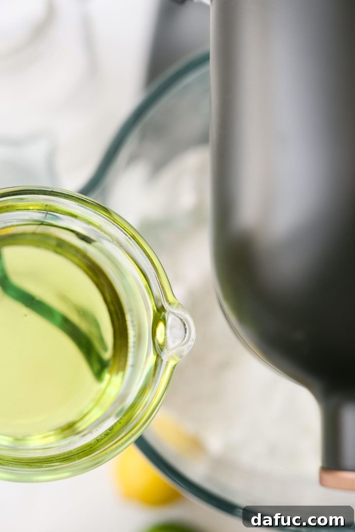 Gradually adding grapeseed oil to the cake mix and Jell-O in a stand mixer.