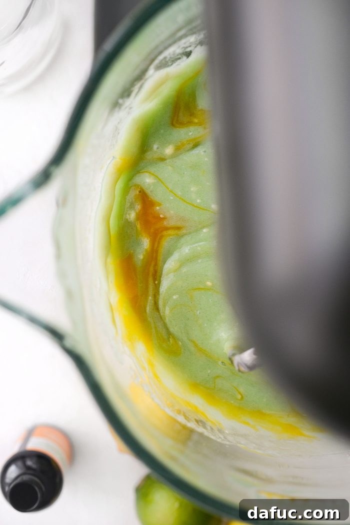 Mixing the cake batter well after each egg is added to ensure a smooth consistency.
