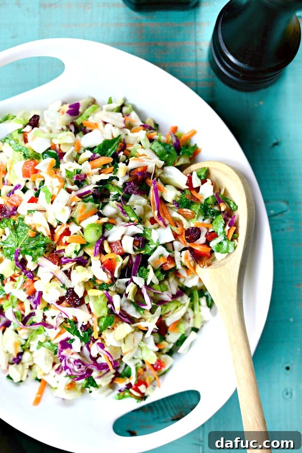 Tossing Rainbow Crunch Salad with dressing.