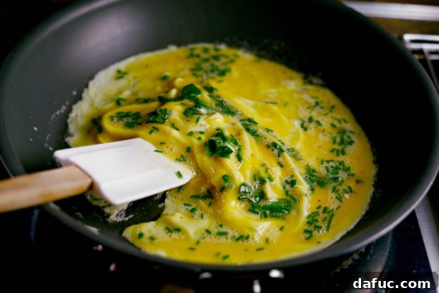 Savory Herb and Parmesan Omelet 2 Pouring egg mixture into a hot skillet