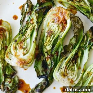 Thumbnail image of grilled baby bok choy, drizzled with ginger chili sauce on a serving dish