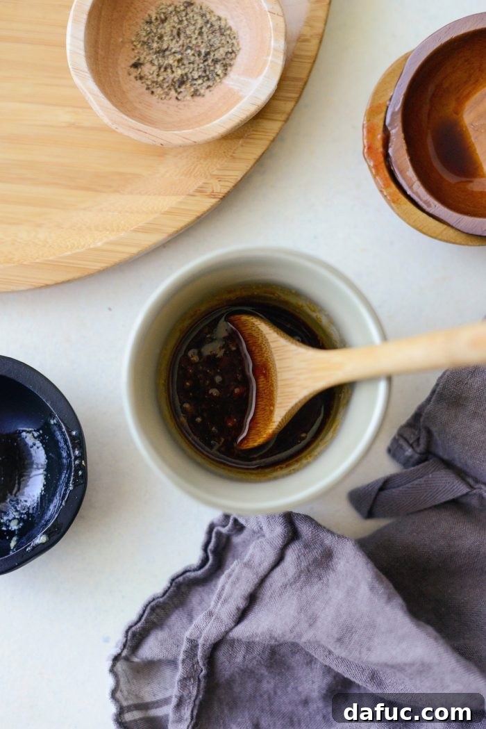 Three essential ingredients for the ginger chili sauce: low-sodium soy sauce, freshly grated ginger, and sambal oelek chili paste, each in a small ceramic bowl