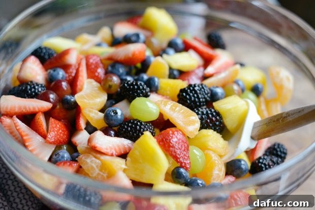 Prismatic Fruit Delight 20 Mixing fruit salad with a spatula
