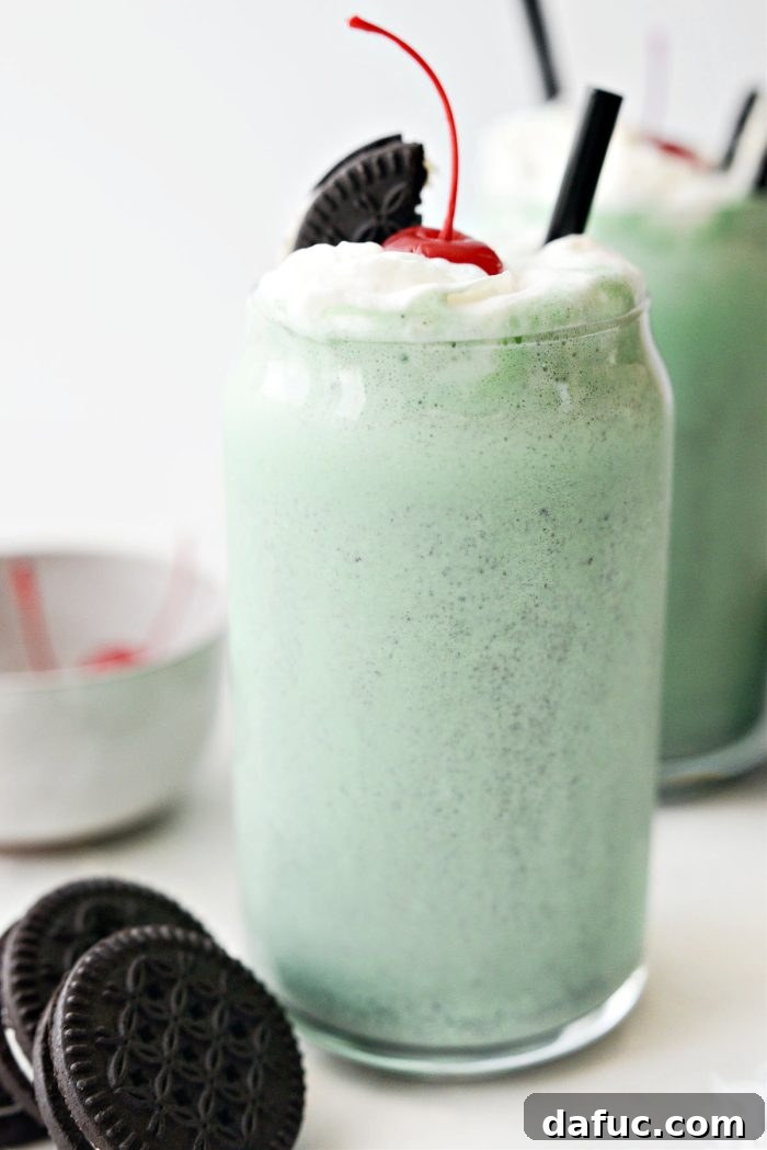 Creamy Cookies and Cream Shamrock Shake topped with whipped cream and a cherry