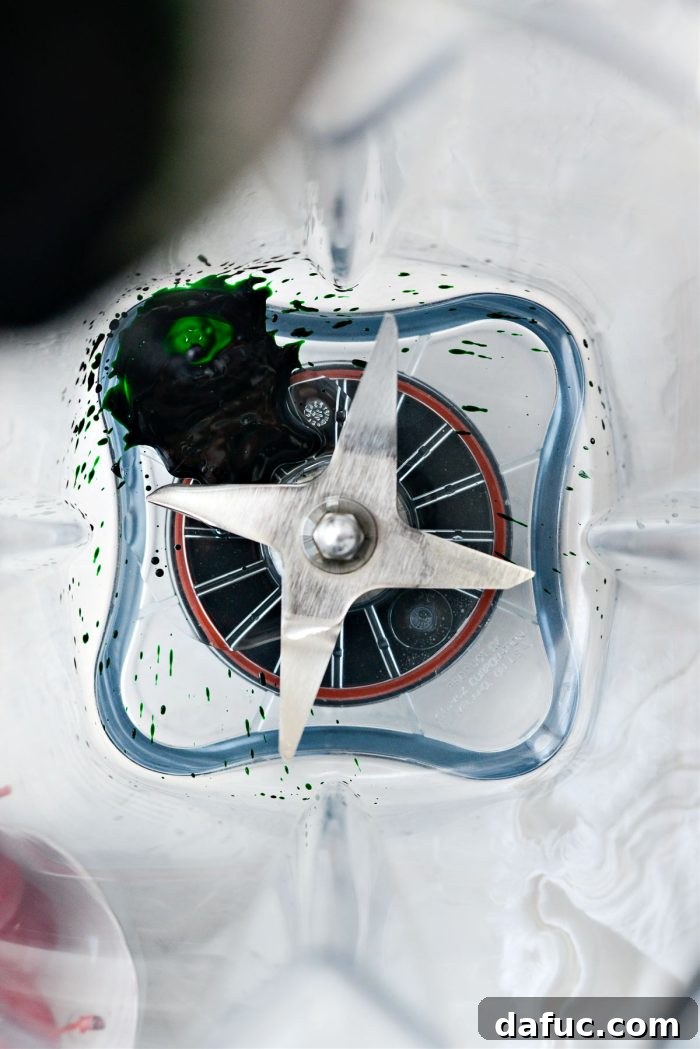 Mint and vanilla extract with green food coloring in a blender
