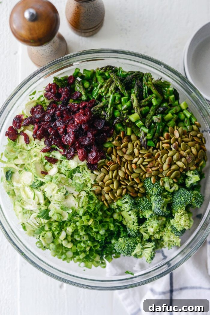 add shredded brussels, asparagus, broccoli, green onion, craisins and toasted pepitas