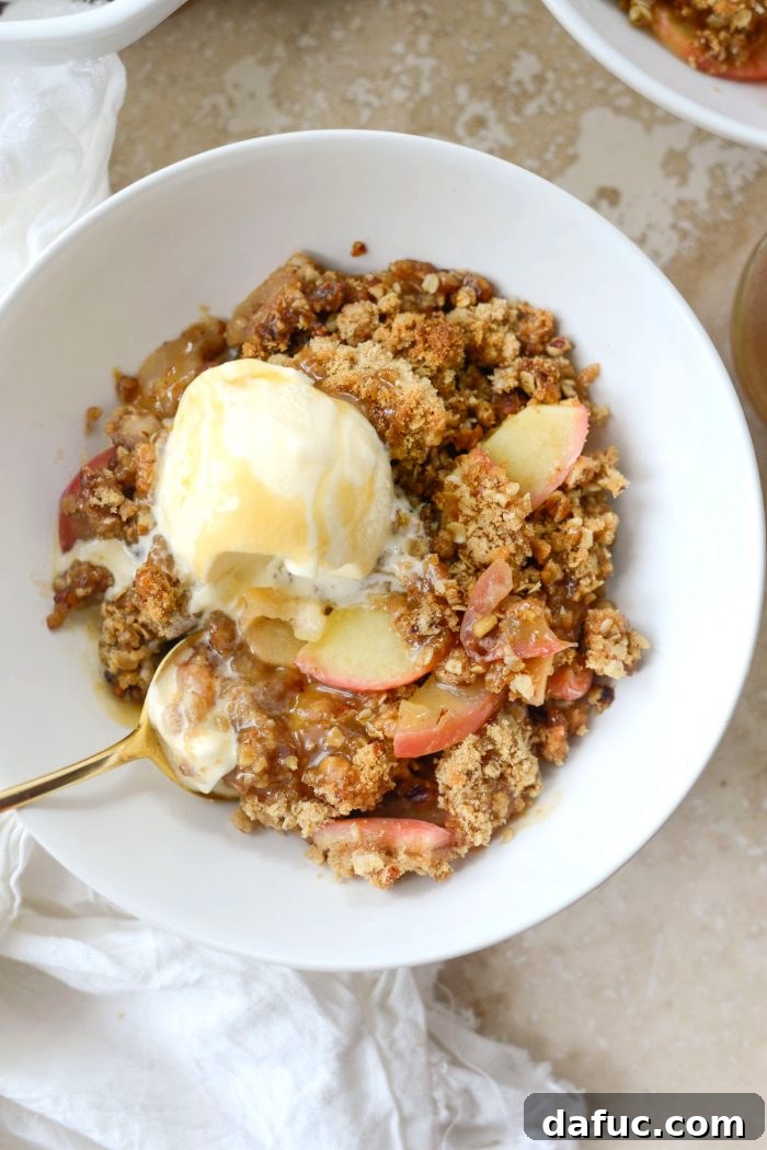 Effortless Apple Crumble 16 Easy apple crisp with a gold spoon taking a bite, showing the texture and warmth.