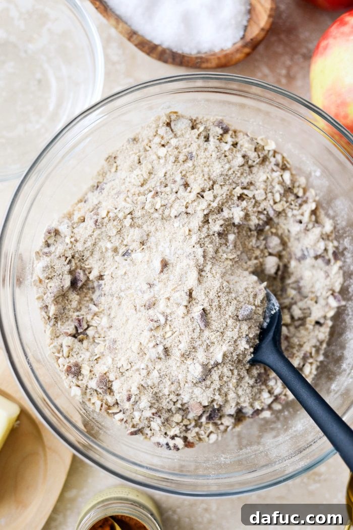 Effortless Apple Crumble 7 All dry ingredients for the apple crisp topping, including pecans, stirred together in a glass bowl.