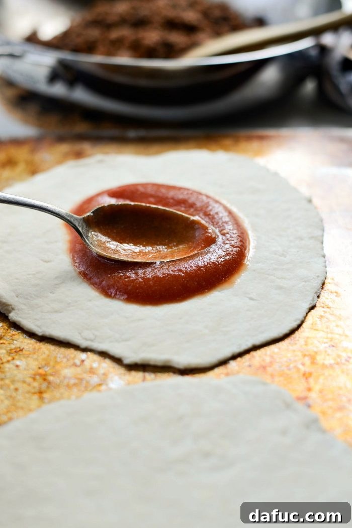 Spreading Fiestada sauce to the edges of the pizza dough