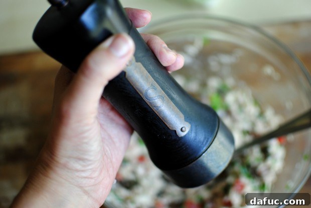 season with salt A pinch of kosher salt being added to the tuna mixture.