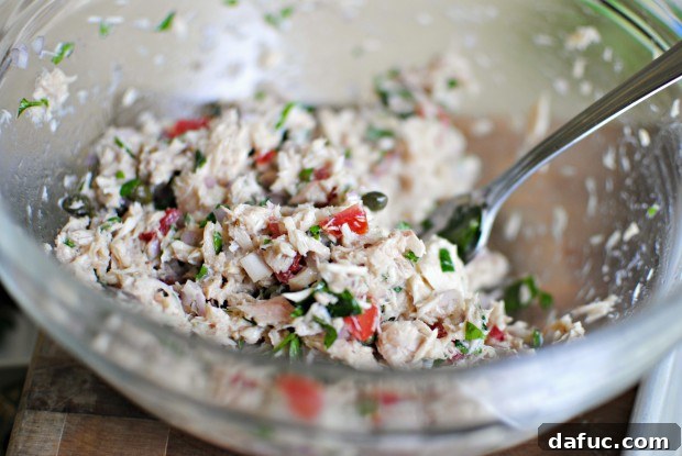 stir The fully mixed tuna salad with vinaigrette in a bowl.