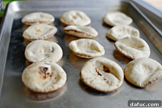 mini pitas Mini pita breads lined up on a baking sheet.
