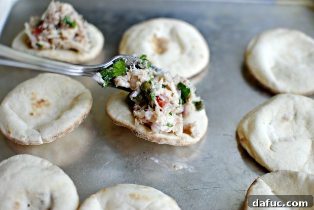 fill Spoonfuls of tuna mixture being placed evenly onto mini pita breads.