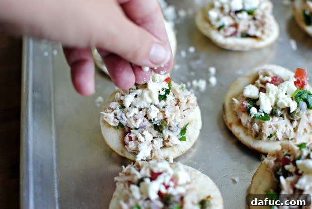top with feta Mini Tuna Melts topped with crumbled feta cheese before baking.