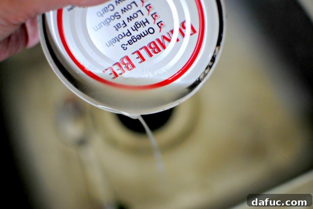 drain A can of albacore tuna being drained in a colander.