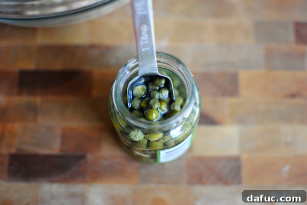 capers Two tablespoons of capers in a small bowl.
