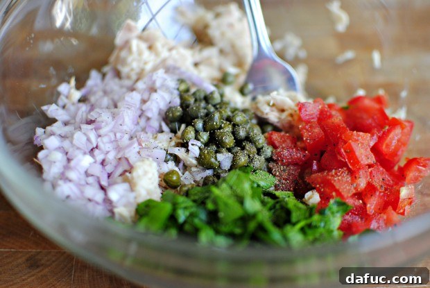 pepper Black pepper being ground over the tuna mixture.