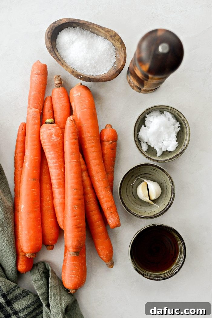 A bowl of fresh carrots, garlic cloves, and a bottle of maple syrup – essential ingredients for maple glazed carrots