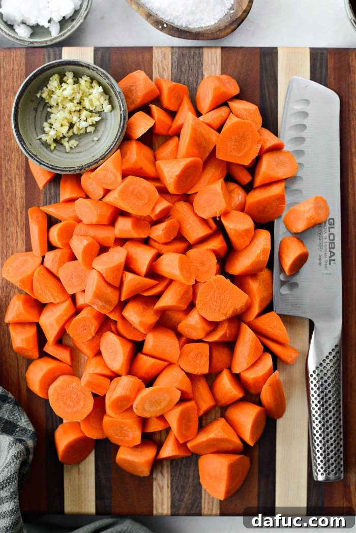 Preparing carrots by roll-cutting and mincing garlic cloves on a wooden cutting board