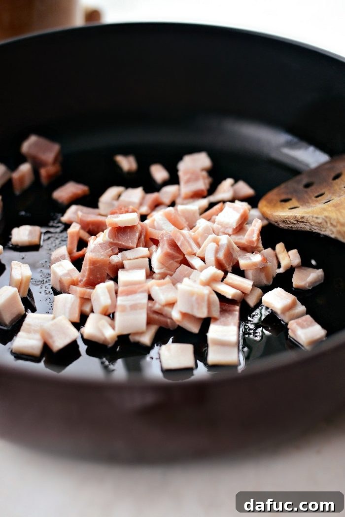 Slow-Braised Beef Short Ribs 4 Diced bacon being added to a deep-sided skillet or Dutch oven with a little oil, ready to be rendered for flavor.