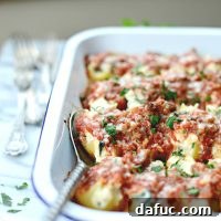 A delicious bowl of Sausage and Arugula Stuffed Shells with chunky tomato sauce.
