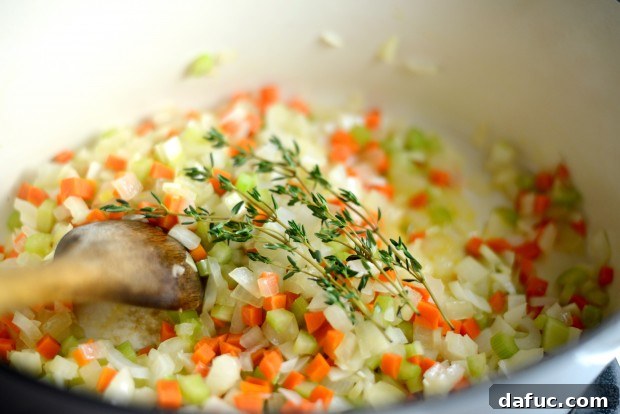 Fresh thyme sprigs added to the sautéed vegetables
