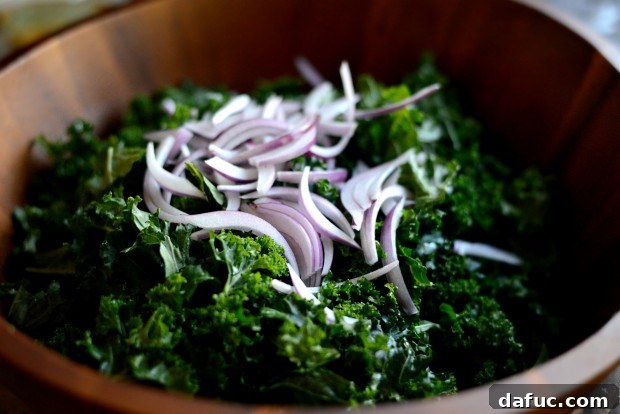 Hearty Winter Kale Salad with Crispy Pancetta and Blue Cheese Crostini 13 Sliced red onions added to the bowl with massaged kale.
