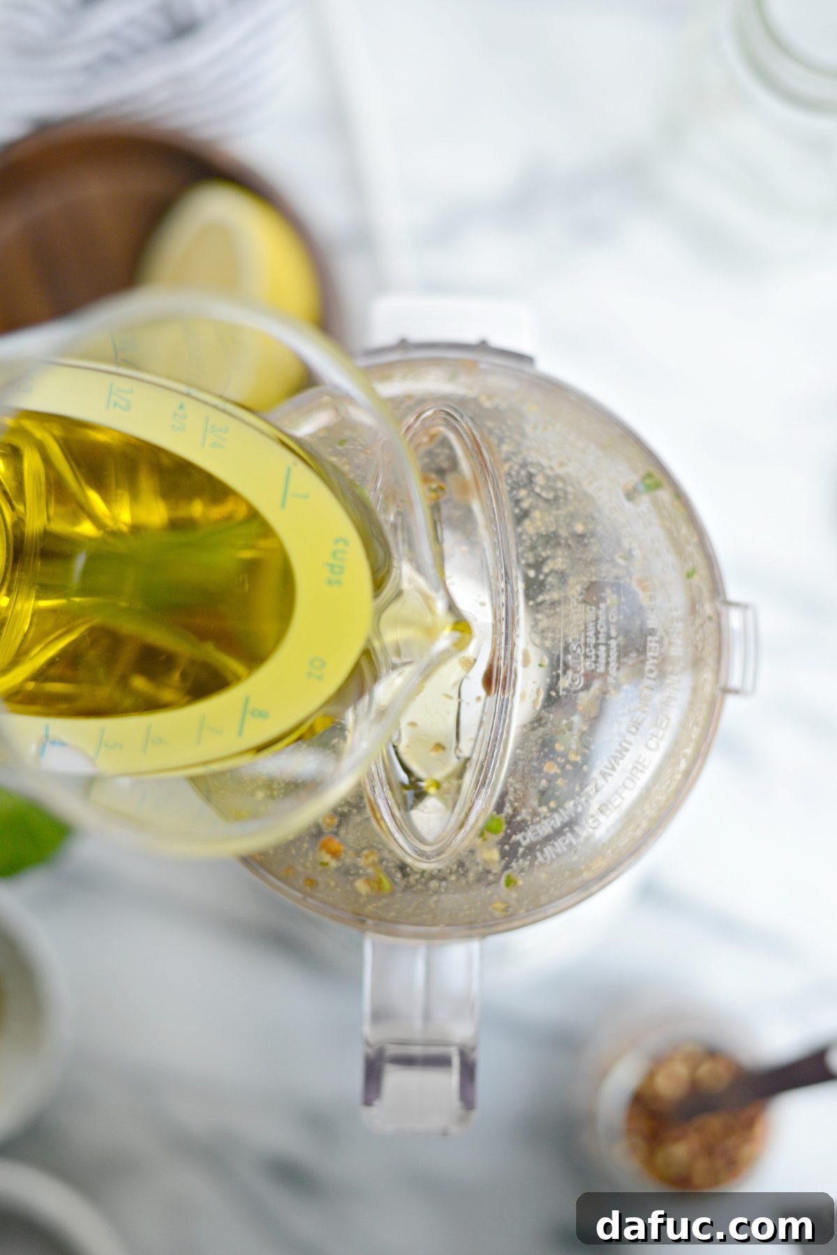 Mixture of basil, garlic, and liquids pulsed together in a food processor
