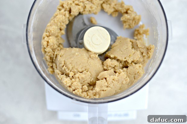Scraping down the sides of the food processor bowl with a spatula
