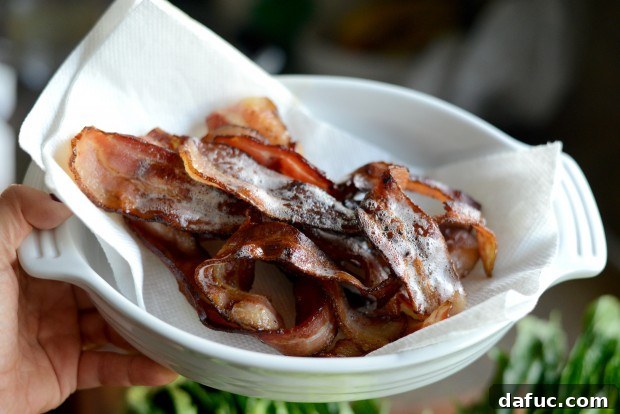 Crispy bacon resting on paper towels to drain excess fat