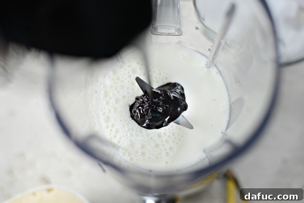 Chocolate Banana Bliss 5 Pouring whole milk into a blender for a milkshake