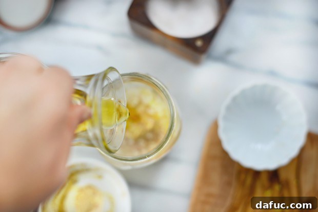 Adding lemon juice, Dijon mustard, and honey to the dressing