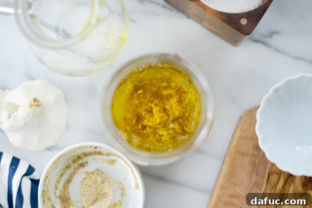 Pouring olive oil into the lemon vinaigrette ingredients