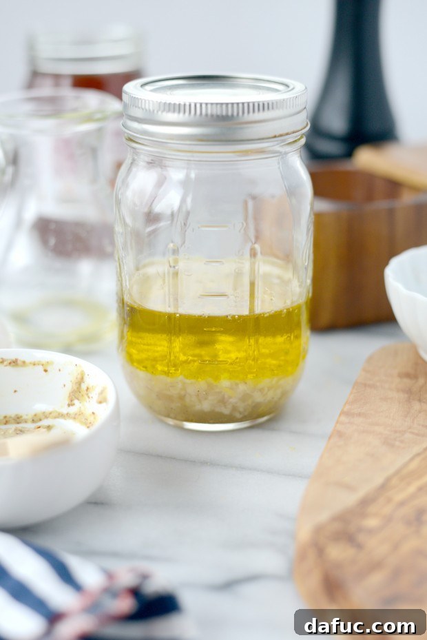 All ingredients for homemade lemon vinaigrette in a jar