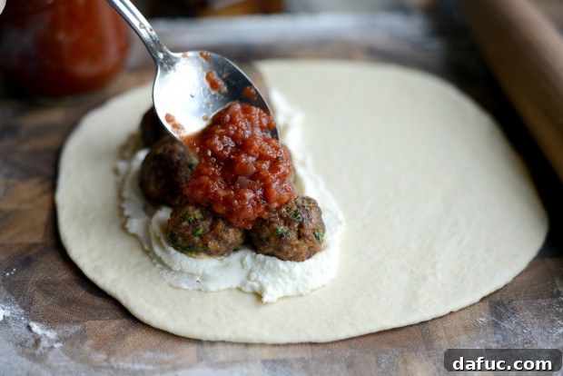 Spoon marinara sauce over meatballs
