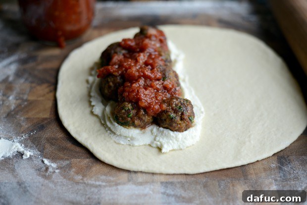 Topping calzones with Fontina and Mozzarella cheese