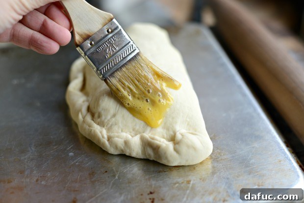 Sprinkling Parmesan cheese on calzones