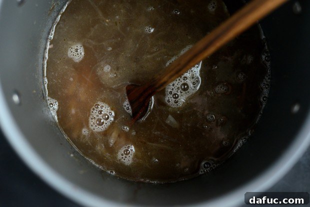 Mixing Broth with Caramelized Onions and Wine