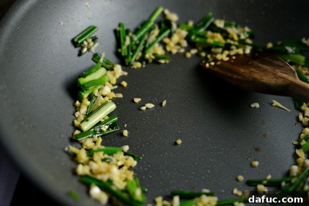 Vibrant Spring Chicken Soba Stir-Fry 12 Sautéing green onions, ginger, and garlic in a wok