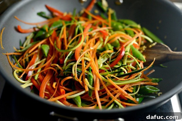 Vibrant Spring Chicken Soba Stir-Fry 14 Adding carrots, zucchini, sugar snap peas, and red bell pepper to the stir-fry