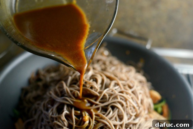 Vibrant Spring Chicken Soba Stir-Fry 18 Cooked soba noodles being added to the stir-fry ingredients