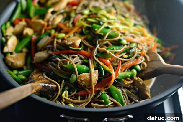 Vibrant Spring Chicken Soba Stir-Fry 19 Miso sauce being poured over the chicken, vegetables, and soba noodles