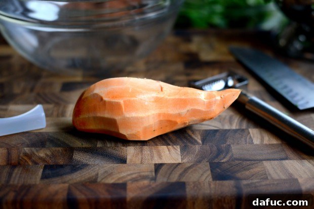 Shaved Raw Sweet Potato and Creamy Avocado Salad with Miso Dressing 13 Peeling a sweet potato and preparing it for julienning, showing the flat surface for stability.
