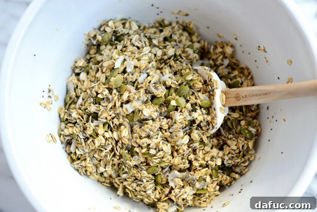 Tropical Coconut Chia Granola 11 Pouring wet mixture over dry granola ingredients