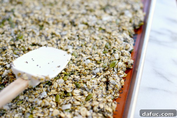 Tropical Coconut Chia Granola 15 Spreading Coconut Chia Granola on baking sheet