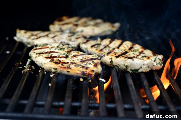 Zesty Grilled Greek Chicken 17 Grilled Greek Chicken cooking on the grates, showing developing grill marks