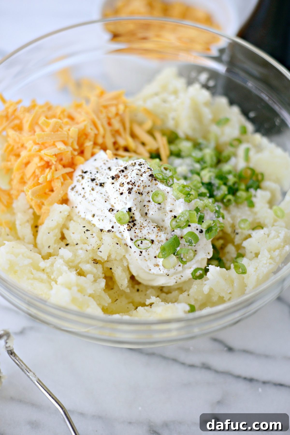 Decadent Double-Baked Potato Delight 9 Adding sour cream, cheese, bacon fat, and green onions to the mashed potatoes