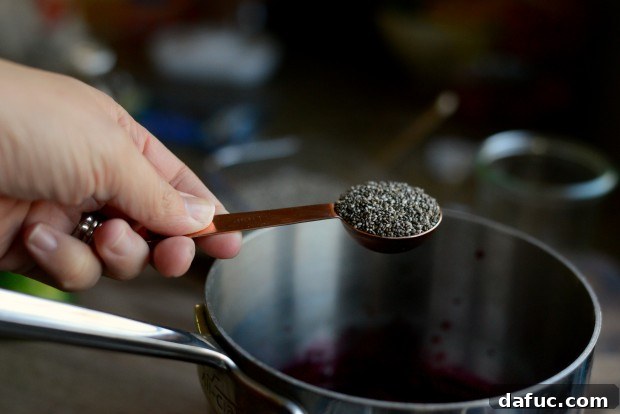 A splash of pure vanilla extract being drizzled into the jam mixture.