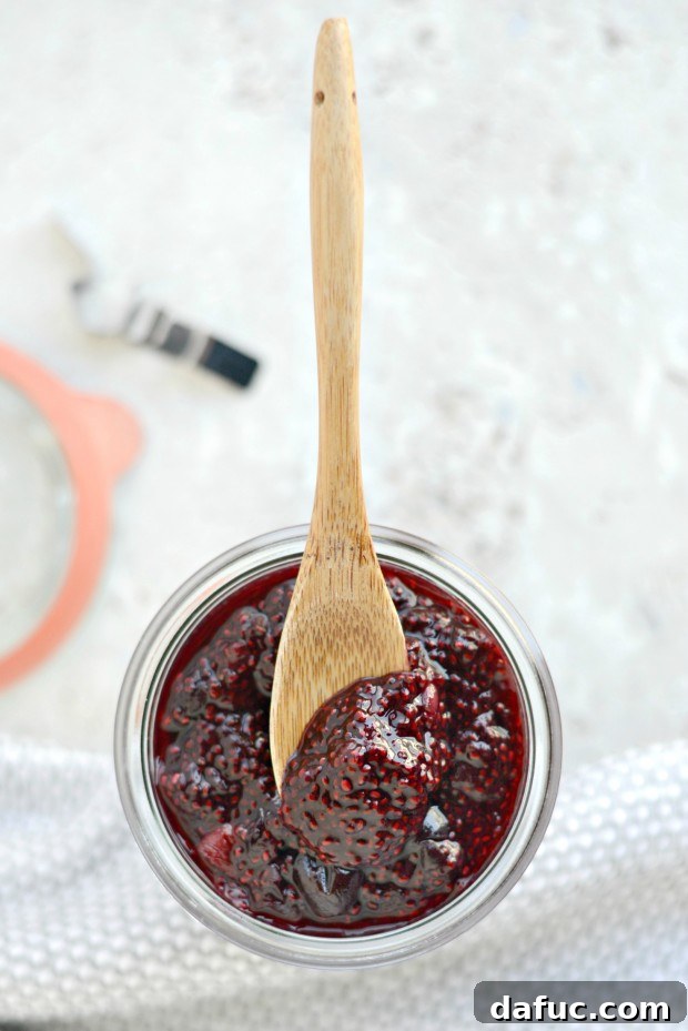Beautifully prepared Cherry Chia Jam in a glass jar, garnished with a fresh cherry.