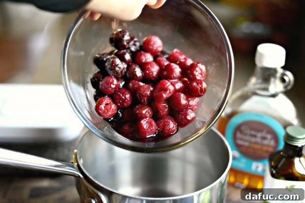 Two rounded cups of partially thawed cherries in a bowl, ready for cooking.